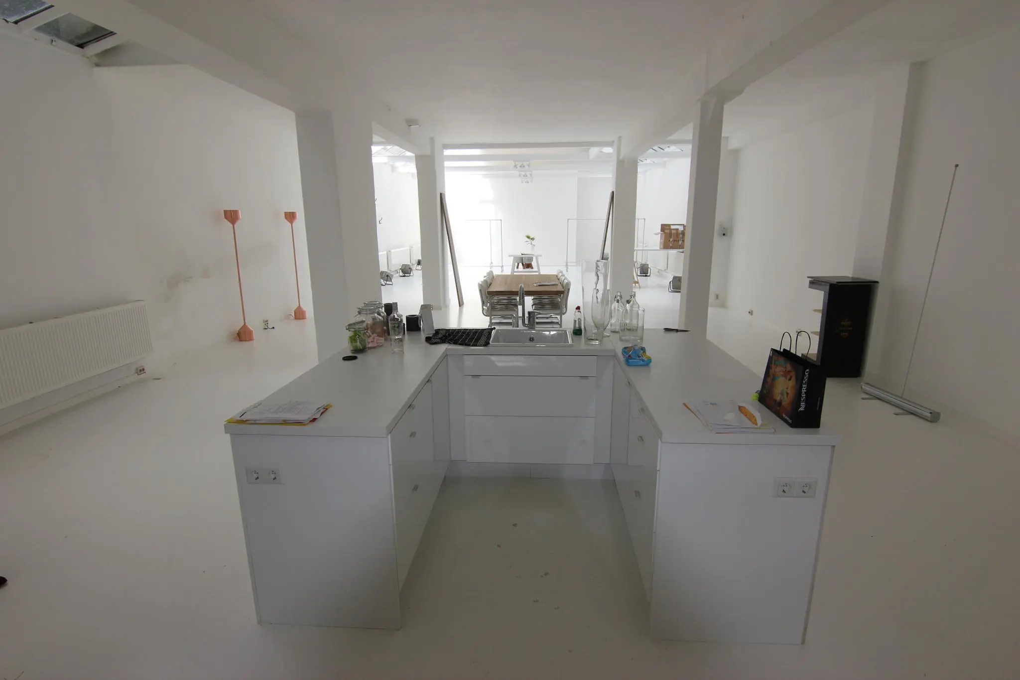 Licht en modern interieur van een ruime werkruimte aan de Graaf Florisstraat met een centraal keukeneiland en vergadertafel op de achtergrond.